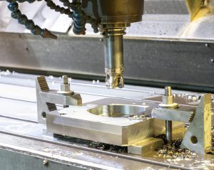 CNC machine operation. CNC machines are used to precisely remove material during the manufacturing process.